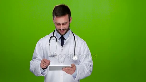 Jovem médico olha para fotos no PC tablet. Tela verde — Vídeo de Stock