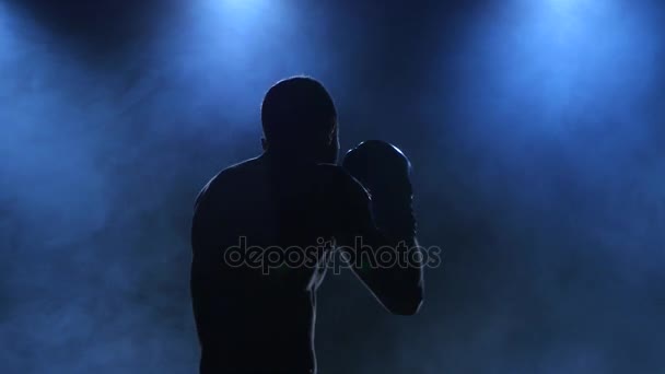 Boxeador muestra entrenamiento antes de la pelea. Silueta sobre fondo oscuro — Vídeos de Stock