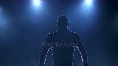 Onun kasların esneme ısınma boksör. Siluet spor organlarının