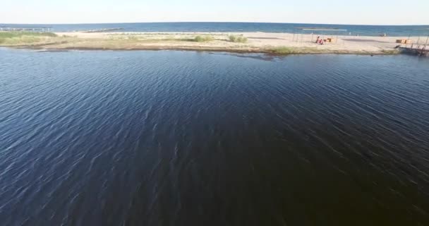 Стрельба низко над заливом и песчаным пляжем и морем — стоковое видео