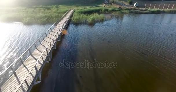 Lungo ponte di legno attraverso un fiume poco profondo. Vista aerea — Video Stock