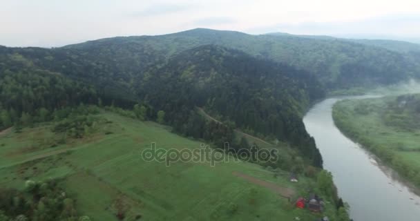 Panoramisch schieten hoog boven de grond beboste heuvels en rivier — Stockvideo