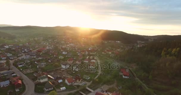 Vista panorámica del amanecer sobre un pequeño pueblo en un valle arbolado — Vídeos de Stock