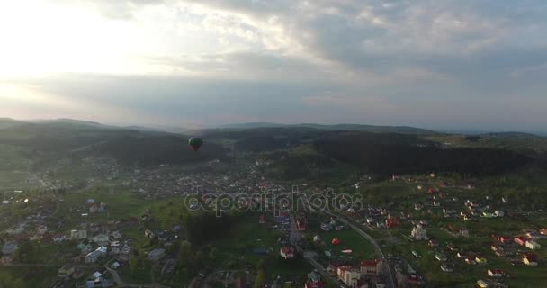 Por encima de la pequeña ciudad hay un globo volador. Vista aérea — Vídeos de Stock