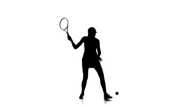 El jugador de tenis golpea la pelota con una raqueta. En cámara lenta. Fondo blanco. Silueta — Vídeo de stock