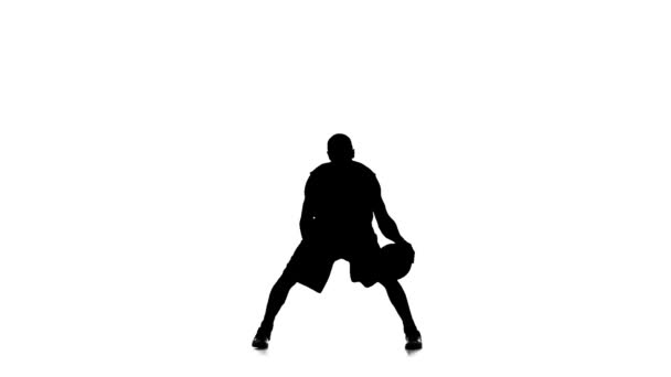 Μπασκετμπολίστας συμπληρώνει την μπάλα. Αργή κίνηση. Σιλουέτα. Λευκό φόντο — Αρχείο Βίντεο