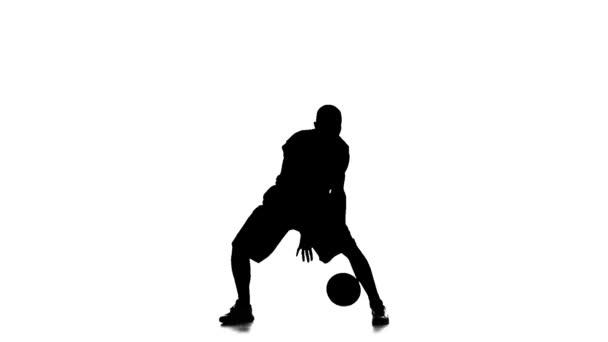 El jugador de baloncesto llena el balón. En cámara lenta. Silueta. Fondo blanco — Vídeo de stock