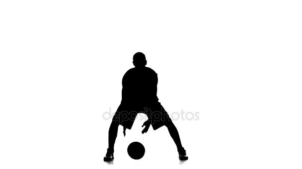 Le joueur de basket remplit le ballon. Au ralenti. Silhouette. Fond blanc 