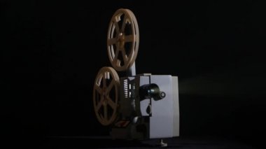 Stüdyoda bir projektör filmde gösterir. Siyah arka plan