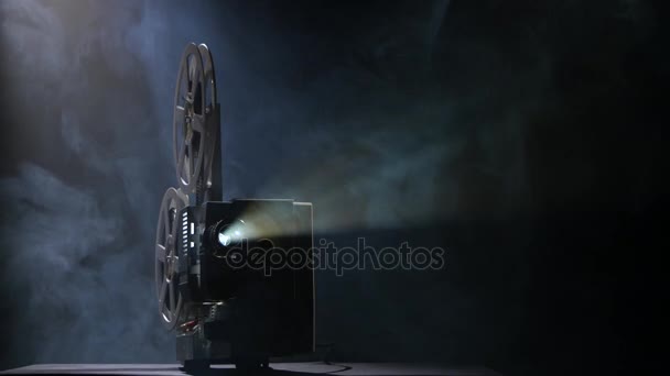 Belysta projektorn i ett mörkt rum visar film — Stockvideo