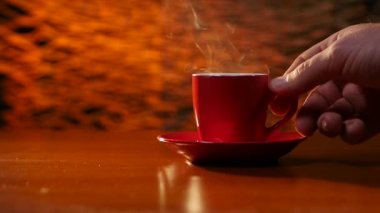 Bir fincan sıcak kahve masanın üzerine koyarak el mans. Ağır çekim