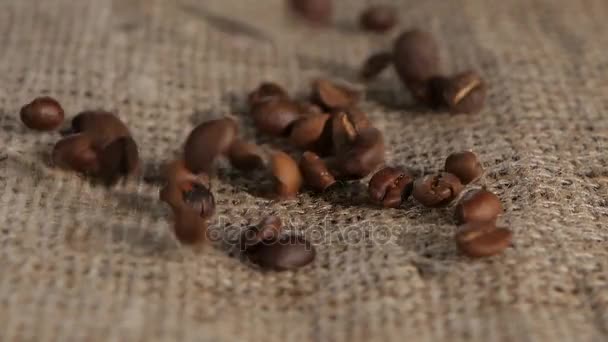 Geselecteerd graan geurende koffie bruin jute vallen op liggen. Close-up — Stockvideo