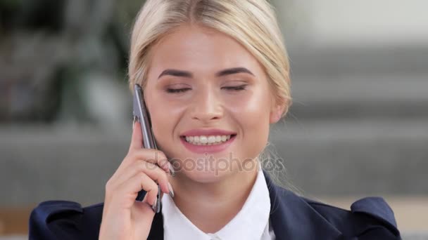 Jeune femme souriante parlant au téléphone — Video