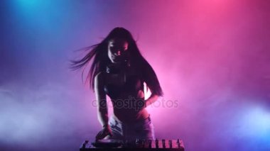 Kız Dj dans mavi pembe ışıklar ve çok fazla duman başlar. Siluet