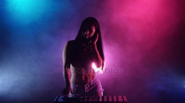 Kız Dj dans mavi pembe ışıklar ve çok fazla duman başlar. Ağır çekim. Siluet