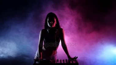 Kız Dj pikaplar arkasında onun pembe mavi ışıklar oynamak. Ağır çekim