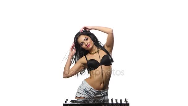 Chica DJ baile sexy, su pelo se desarrolla en un viento. Fondo blanco — Vídeo de stock