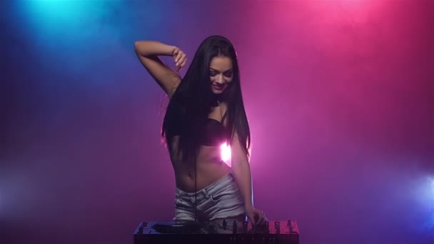 Chica DJ bailando y jugando en los tocadiscos. Luces coloridas. Movimiento lento — Vídeos de Stock