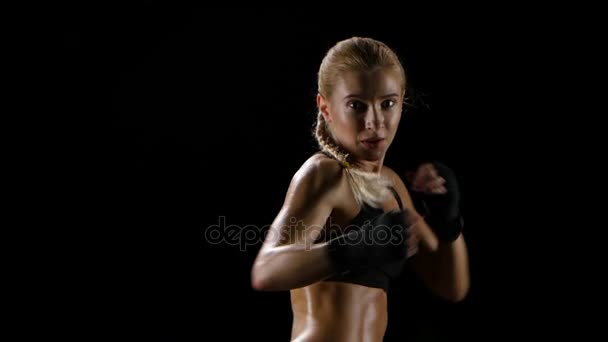 女性ボクサーの暗いスタジオで自分自身をトレーニングします。スローモーション — ストック動画