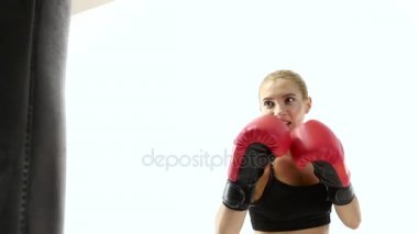 Yakın çekim kadın boksör darbeler kum torbası için yapar.