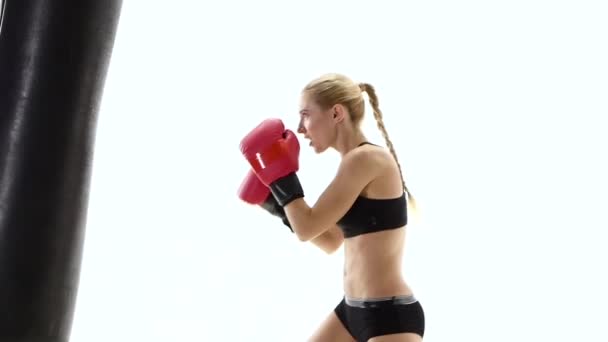 Sportswoman boxing champion fulfills blows on the punching bag — Stock Video