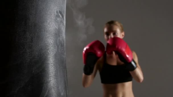 Boxeadora deportiva golpea fuera del saco de boxeo. Movimiento lento — Vídeo de stock