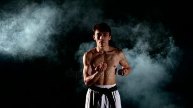 Karate veya taekwondo adam çıplak bir gövde ve bir siyah kuşak, duman, yakın çekim