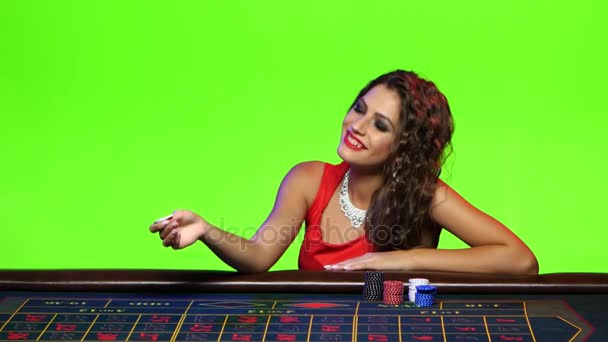 Sexy chica juega con chip sentado en la mesa de póquer — Vídeos de Stock