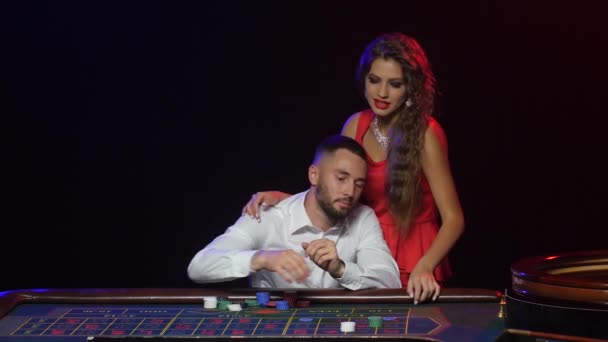 Flickan ger lycka till mannen i spelet av roulette — Stockvideo