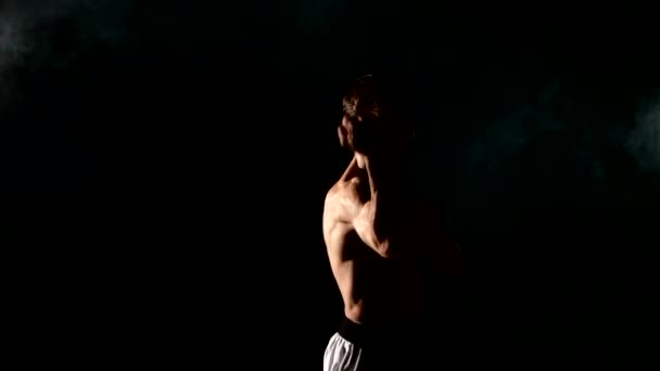 Kung-fu ou karaté homem praticando artes marciais sobre fundo cinza, fumaça — Vídeo de Stock