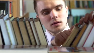 Çocuk bir kitap kütüphanede seçer. yakın çekim