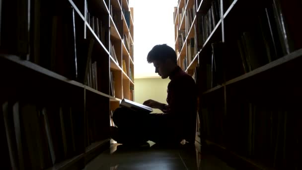 Sziluettjét főiskolai hallgató emeleti könyvtárban ül