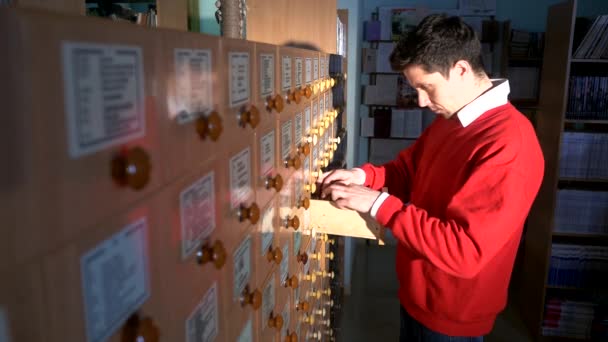 Buscando en los archivos. Estudiante buscando desde un gabinete de llenado — Vídeo de stock