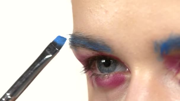 Eye make-up kvinna ansöker eyeshadow, att göra exotiska, one, blå ögonbryn, närbild, vit — Stockvideo