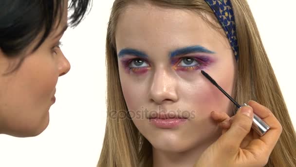 Eye make-up kvinna ansöker eyeshadow, vilket gör exotiska, one, blå, gul ögonbrynsskugga, mascara, närbild, vit — Stockvideo