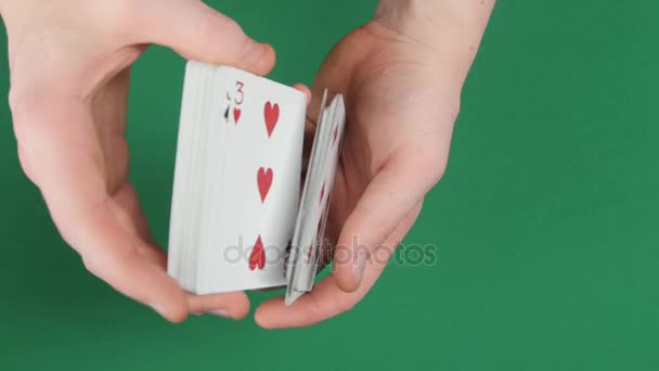Jogando cartas sendo embaralhar em uma superfície verde pelo mágico — Vídeo de Stock