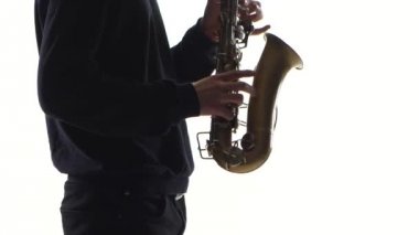 Müzisyen eski bir saksofon çalıyor. Beyaz arka plan üzerinde portre