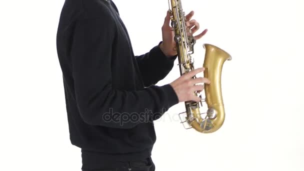 Saxofón en solitario. Interpretando a un joven músico en un estudio blanco — Vídeos de Stock