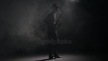 Müzik saksafon. Adam bir karanlık dumanlı Studio tarafından gerçekleştirilen