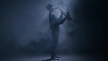 Saksofoncu bir karanlık dumanlı stüdyoda bir enstrüman çalma