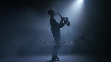 Saksafon oynamaya spot müzisyen adam. Dumanlı stüdyo