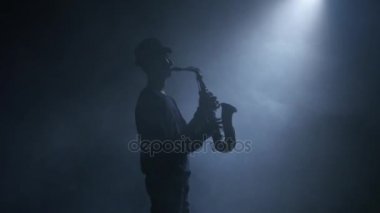 Saksafon. Dumanlı bir stüdyoda bir enstrüman çalmaya adam müzisyen