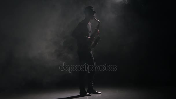 Saxophone musical. Interprété par un homme dans un studio sombre et fumé — Video