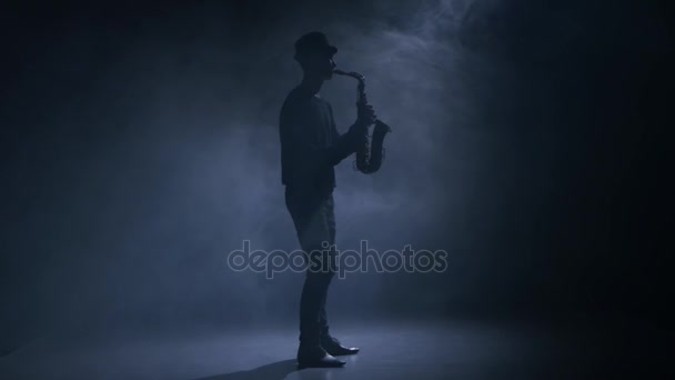 W człowieku ciemnego dymu studio, gra na saksofonie — Wideo stockowe