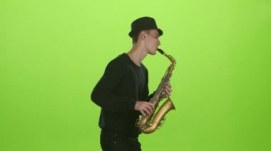 Üzerinde altın müzik aleti çalma saksofoncu. Yeşil ekran