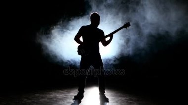 Cihazda bir duman bulutu içinde oynayan iddialı gitarist