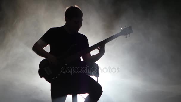 Le musicien de studio fumé jouant de la guitare assis sur une chaise — Video