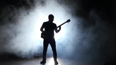 Müzisyen atlamak bas gitar çalarken. Koyu duman