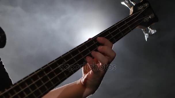 Hombre tocando en la guitarra un concierto de rock. Primer plano bajo guitarra — Vídeo de stock