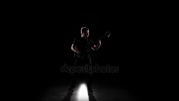 Baixo guitarrista toca uma música de joelhos. Movimento lento — Vídeo de Stock